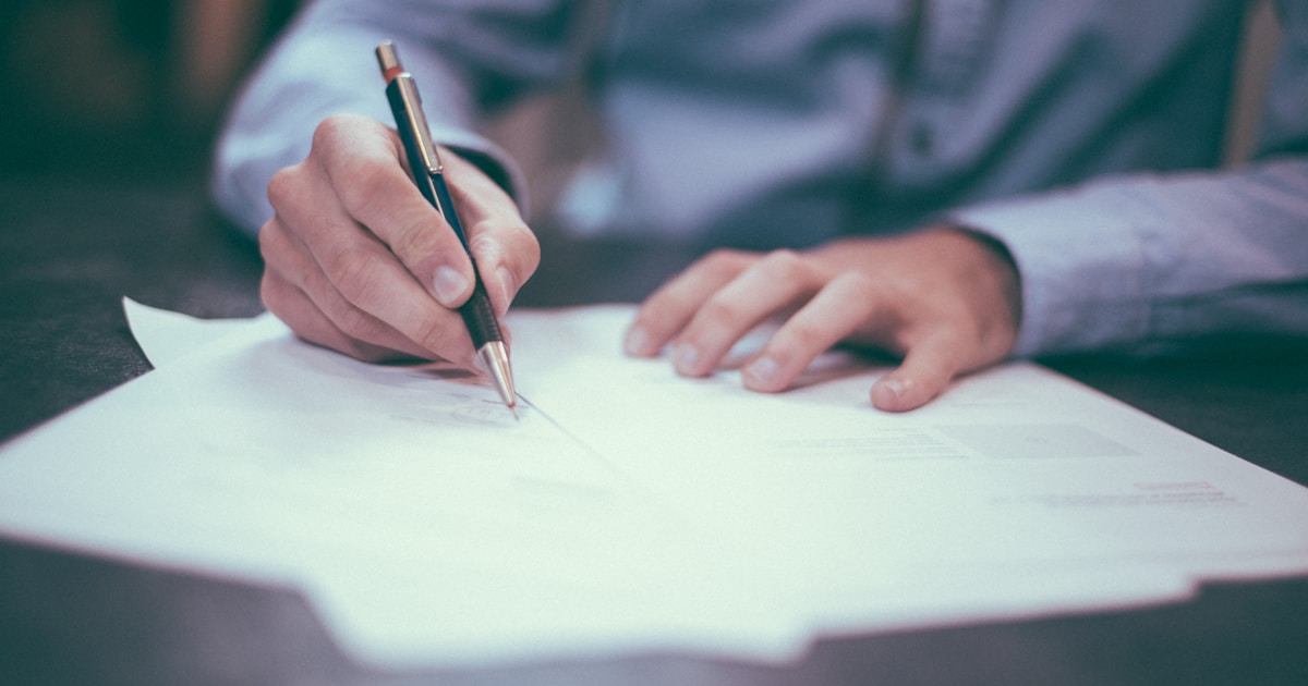 Person reviewing auction documents and property records at a desk